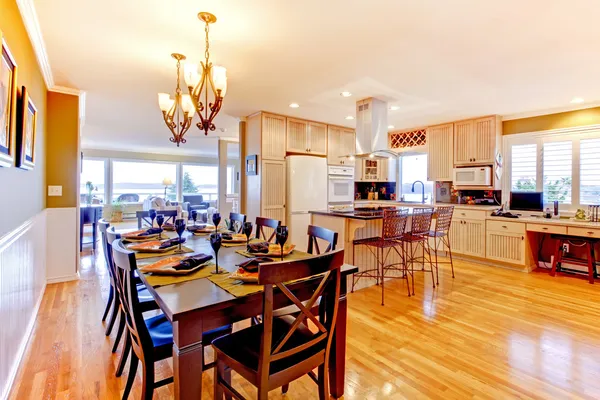 Large luxury dining room and kitchen witj shiny wood floor.