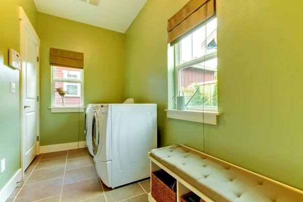 Green large bathroom with white washer and dryer.