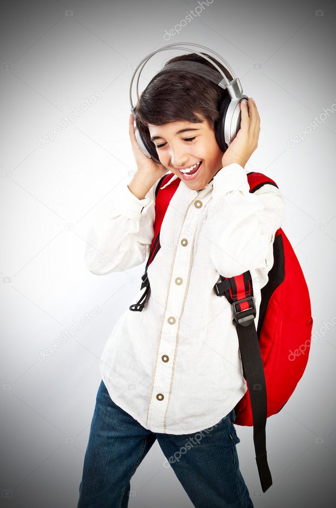 Pretty teen boy enjoying music holding head with headphones 