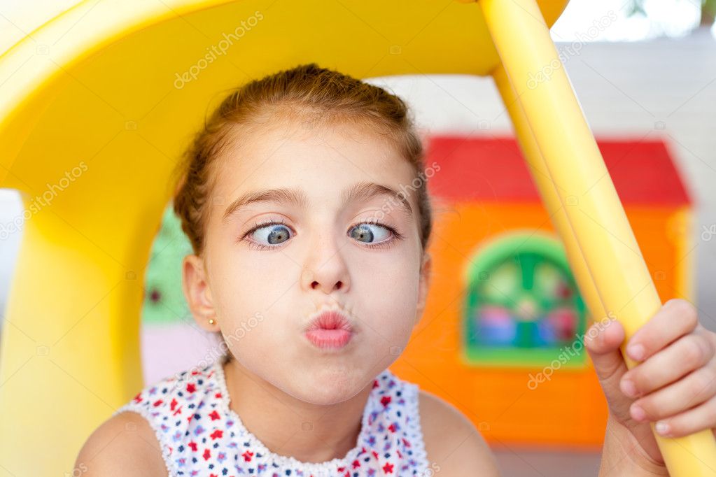 Cross eyed squinting expression little girl in playground