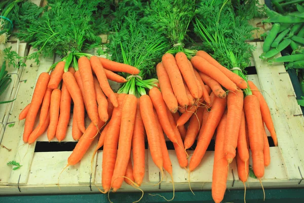 Bunches of fresh carrots on a market stall