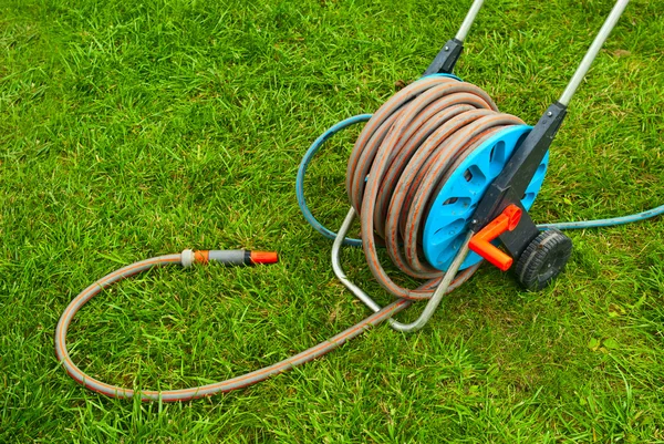 Hose for watering the garden on the green grass — Stock Photo #7224814