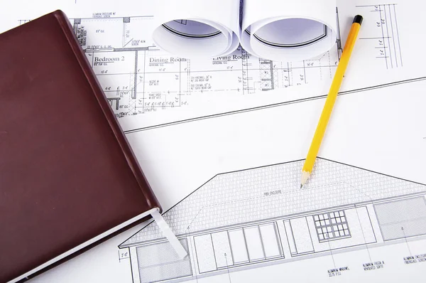 Pencil, diary, blueprints on desktop