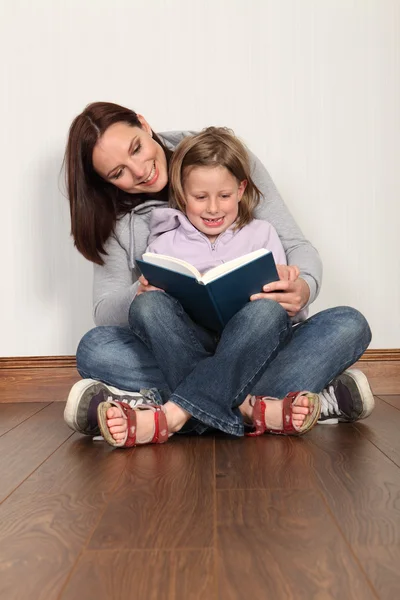 Mother teaching daughter to read home education