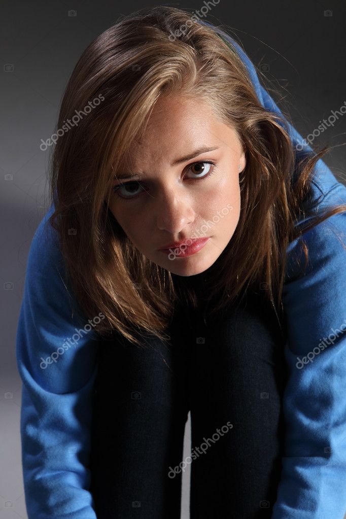 Distressed and frightened young blonde teenager girl sitting on floor Distressed and frightened young blonde teenager girl sitting on floor