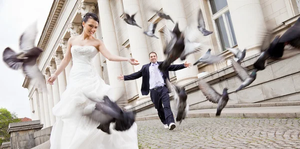 Bride and groom walking behind doves