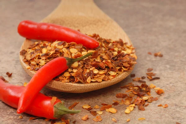 Red chili peppers and red pepper flakes on a spoon