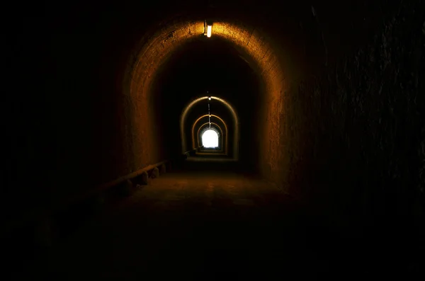 Tunnel illuminated with light at the end