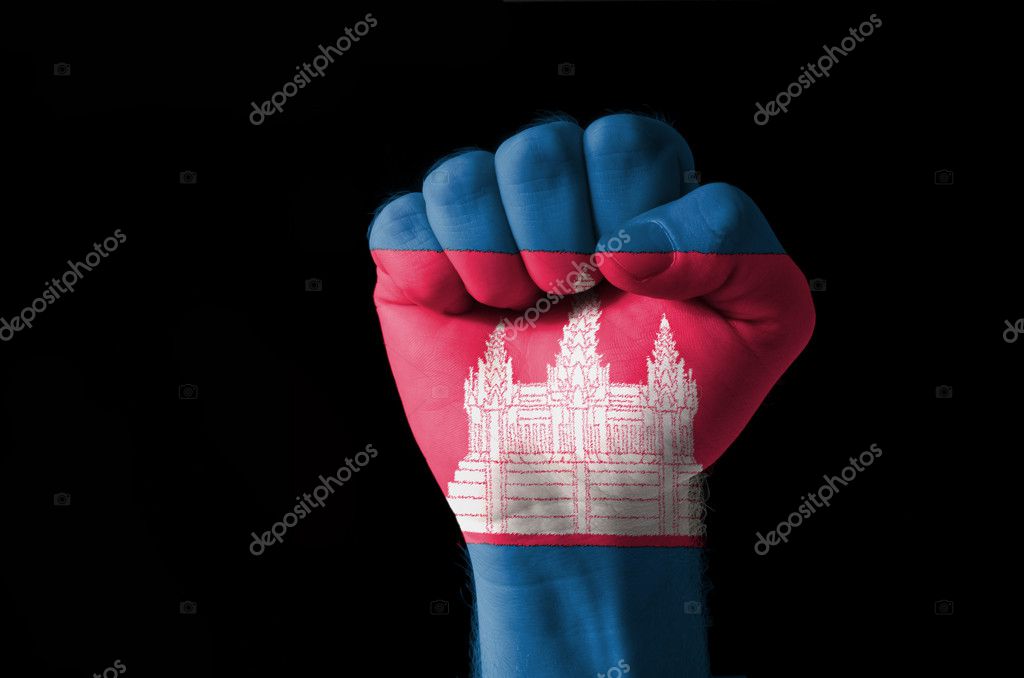 Low key picture of a fist painted in colors of cambodia flag