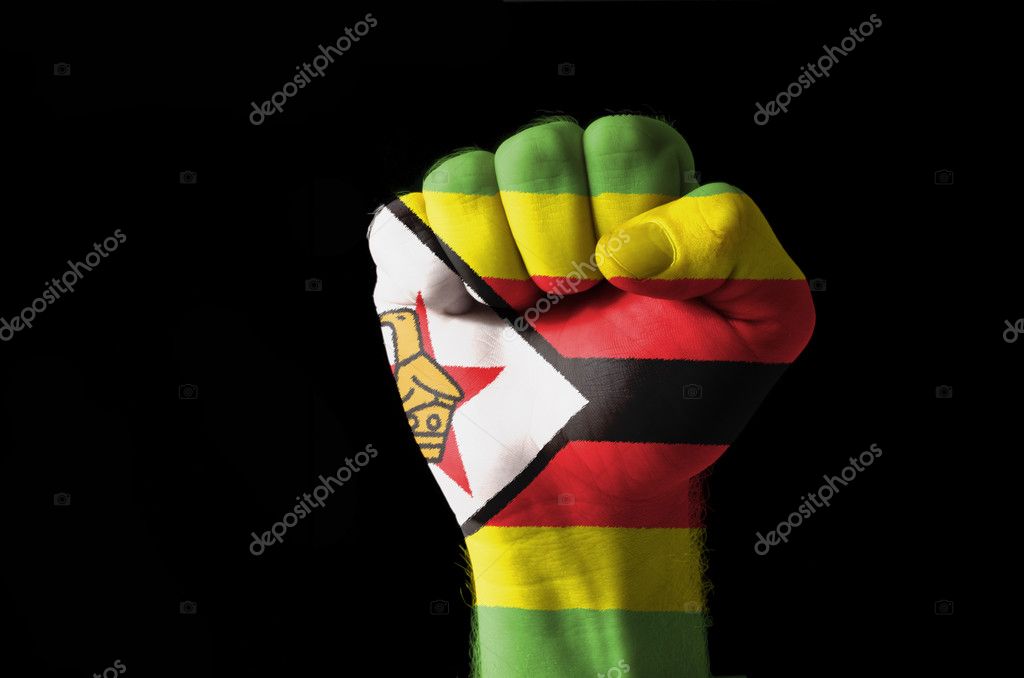 Low key picture of a fist painted in colors of zimbabwe flag