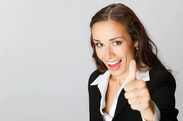 Businesswoman with thumbs up, over grey