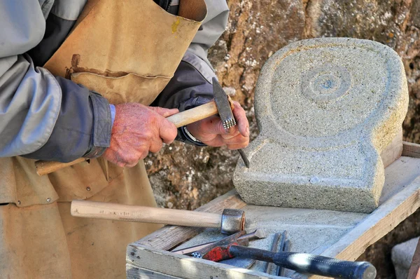 Man at work while sculpting the stone