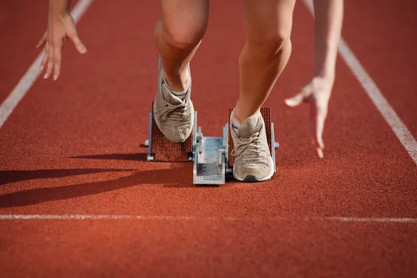 Action packed close-up image of a female athlete leaving the starting block