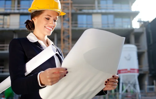 Young female architect/construction engineer reviewing plans at