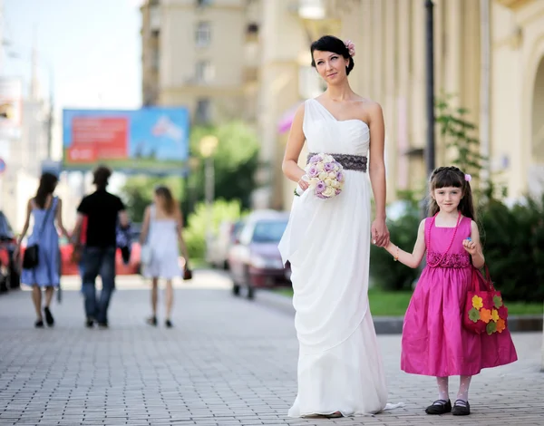 Beautiful bride posing together with flowergirl