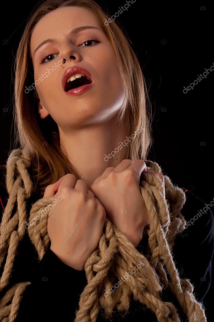 Seductive young girl tied in ropes on black background girl tied