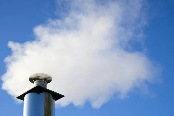 Industrial smoke from chimney on blue sky