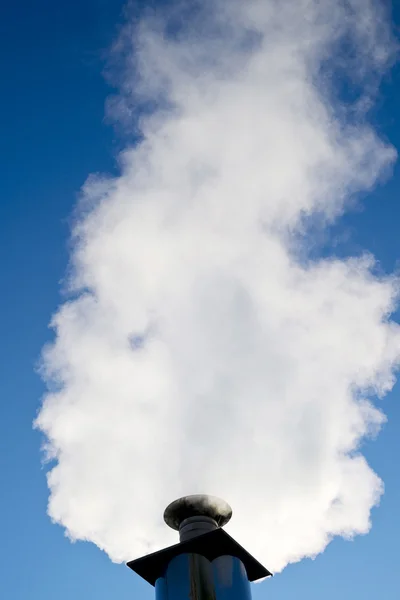 Industrial smoke from chimney on blue sky