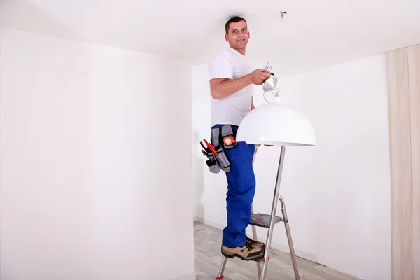 Handy-man fixing ceiling light