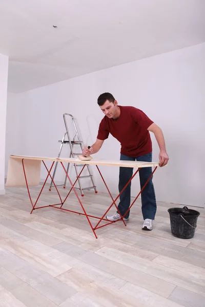 Handyman applying glue on wallpaper