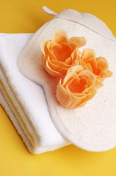 Towel with scented bath flowers and glove