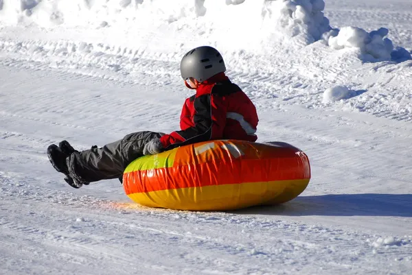 Child sledding on inner tube