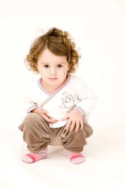 Portrait of Baby Girl Squatting by Jesse Kunerth Stock Photo