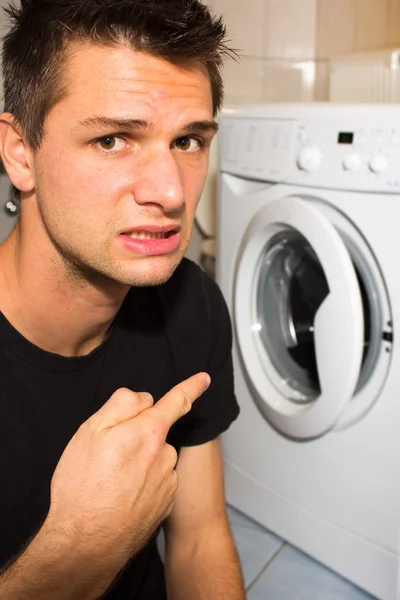 Young man unhappy with washing mashine