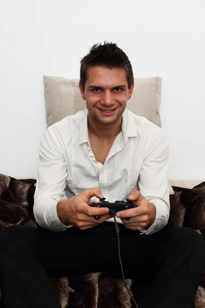 Smiling Gamer sitting on couch with controller and playing