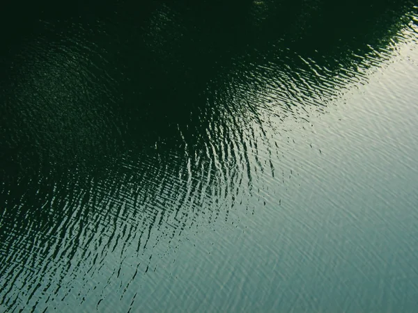 Light and shadow on rippling water surface