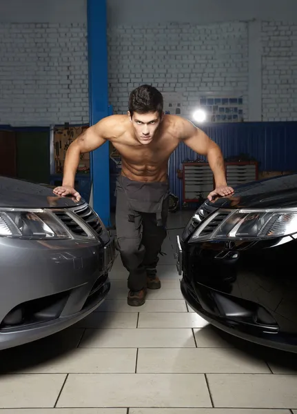 Fashion portrait of a young muscular man standing near the car