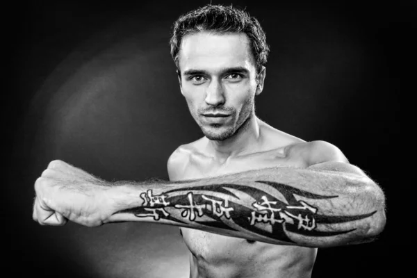 Man showing hand with tattoo black and white focus on face