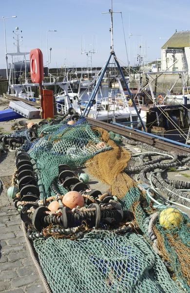 Fishing nets and buoys with harbour scene at Pittenweem