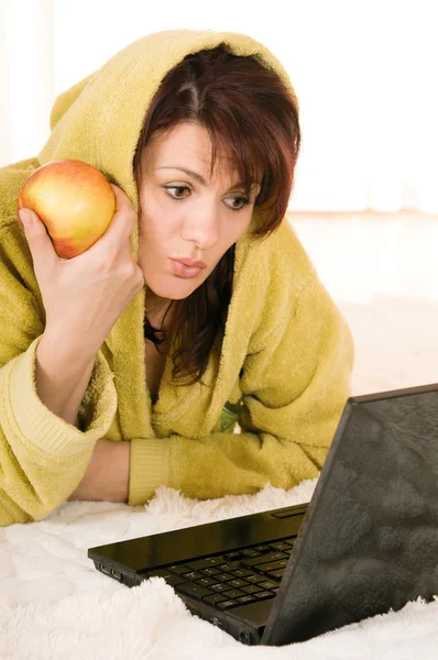 Жінка з ноутбуком і яблуком — стокове фото
