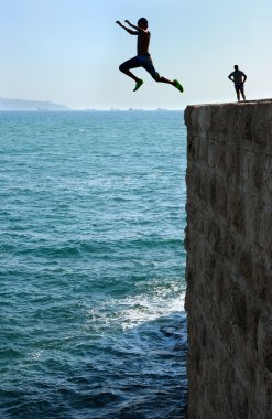 Teens, jumping into the sea. clipart