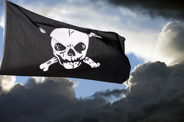 Веселый Роджер (пиратский флаг) против грозовых облаков — стоковое фото