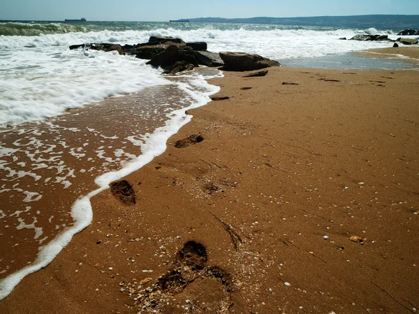 Zee surf en voetafdruk over zand — Stockfoto