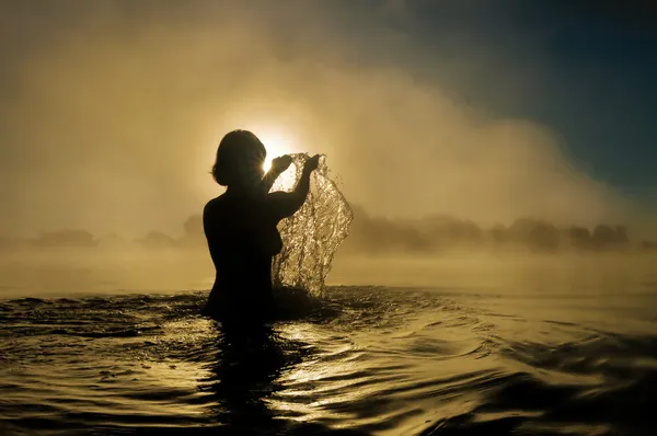 Vrouw spetteren in water — Stockfoto