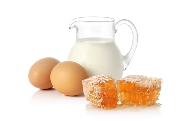 Свежее молоко, два яйца и мед — стоковое фото