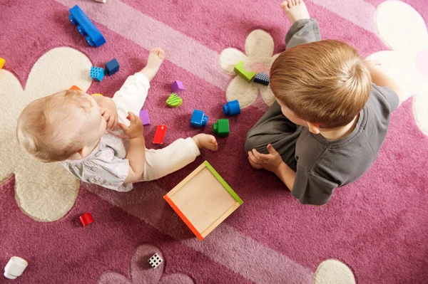 Брат і сестра грають з іграшковими блоками — стокове фото