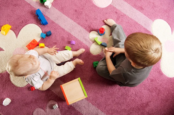 Irmão e irmã brincando com blocos de brinquedo — Fotografia de Stock