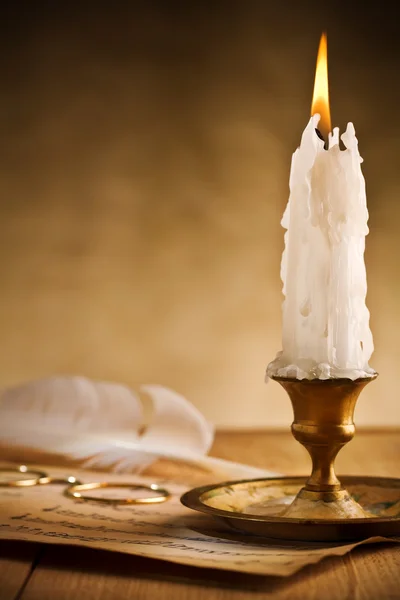 Античный латунный подсвечник с горящей свечой — стоковое фото