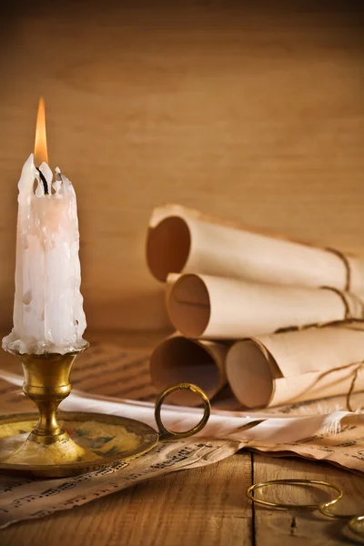 Свеча и старый рулон бумаги — стоковое фото