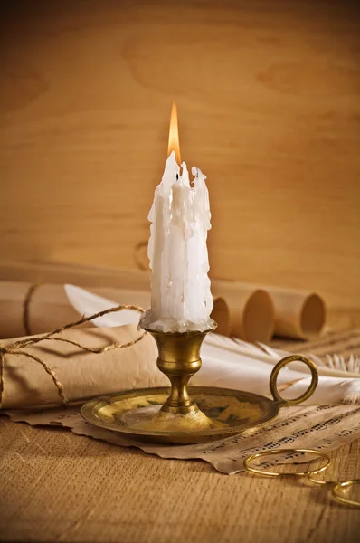 Vista sobre la vela encendida con hoja de notas antiguas Imagen de stock