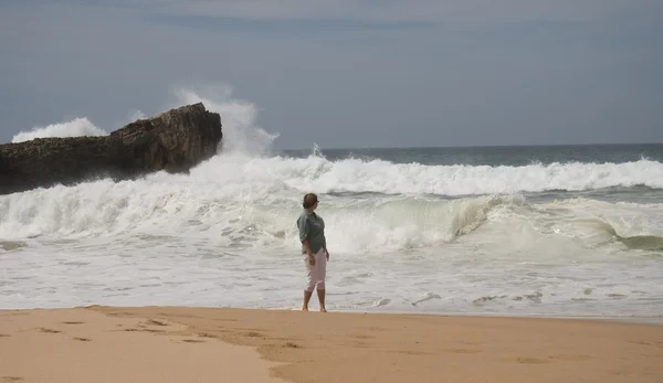 Woman is looking on wave in Atlantic ocean — Stock Photo, Image
