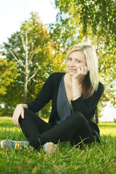 Krásná dívka, spočívající v parku na trávě — Stock fotografie