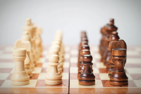 Placa de xadrez com figuras em fundo cinza — Fotografia de Stock