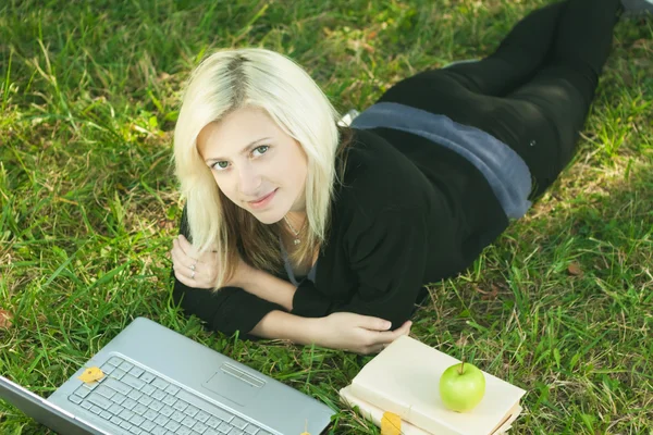 Krásná dívka studuje v parku s notebookem — Stock fotografie