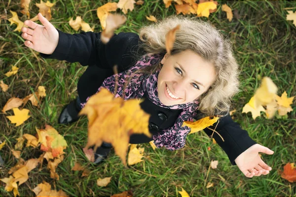 Happy girl under the tree with falling leafs