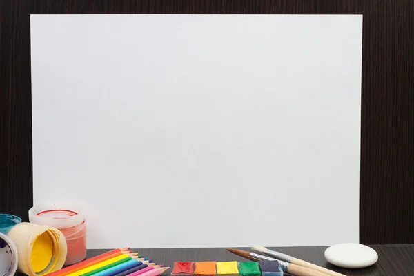 Hoja de papel en blanco con pinturas y lápices de colores — Foto de Stock
